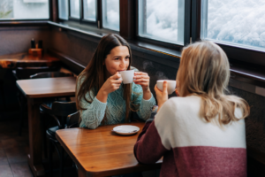 Two friends catching up over coffee in a cafe