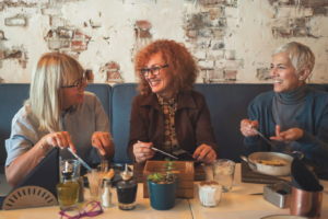 3 female friends enjoying socializing together at a cafe