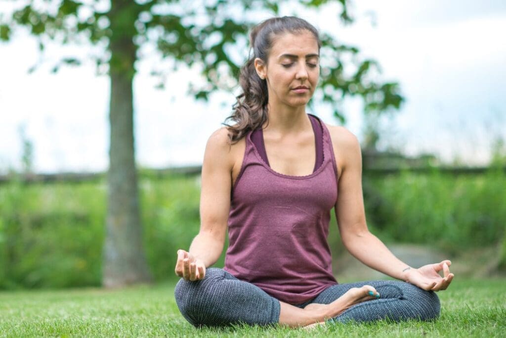 Woman meditating on the grass building resistance