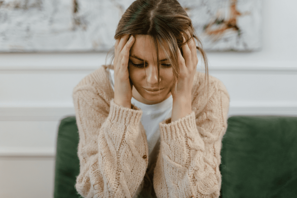 Woman with head in hands feeling emotionally overwhelmed