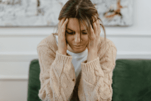 Woman with head in hands feeling emotionally overwhelmed