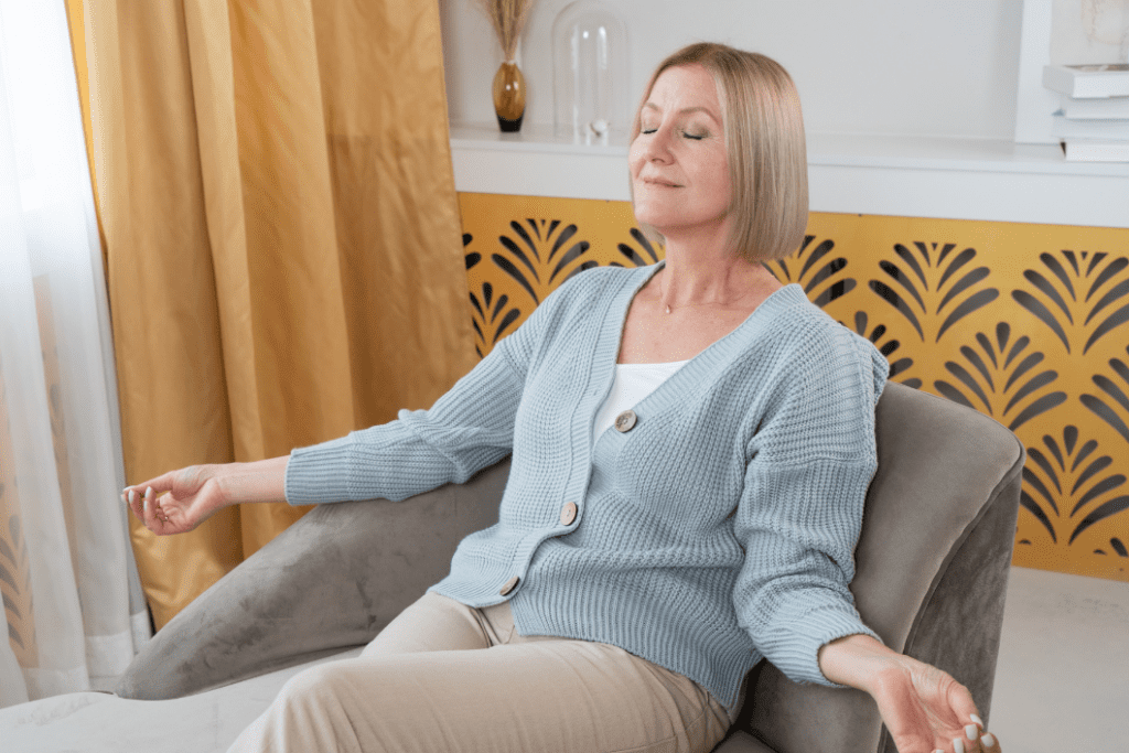 Woman sitting on couch doing breathing exercises